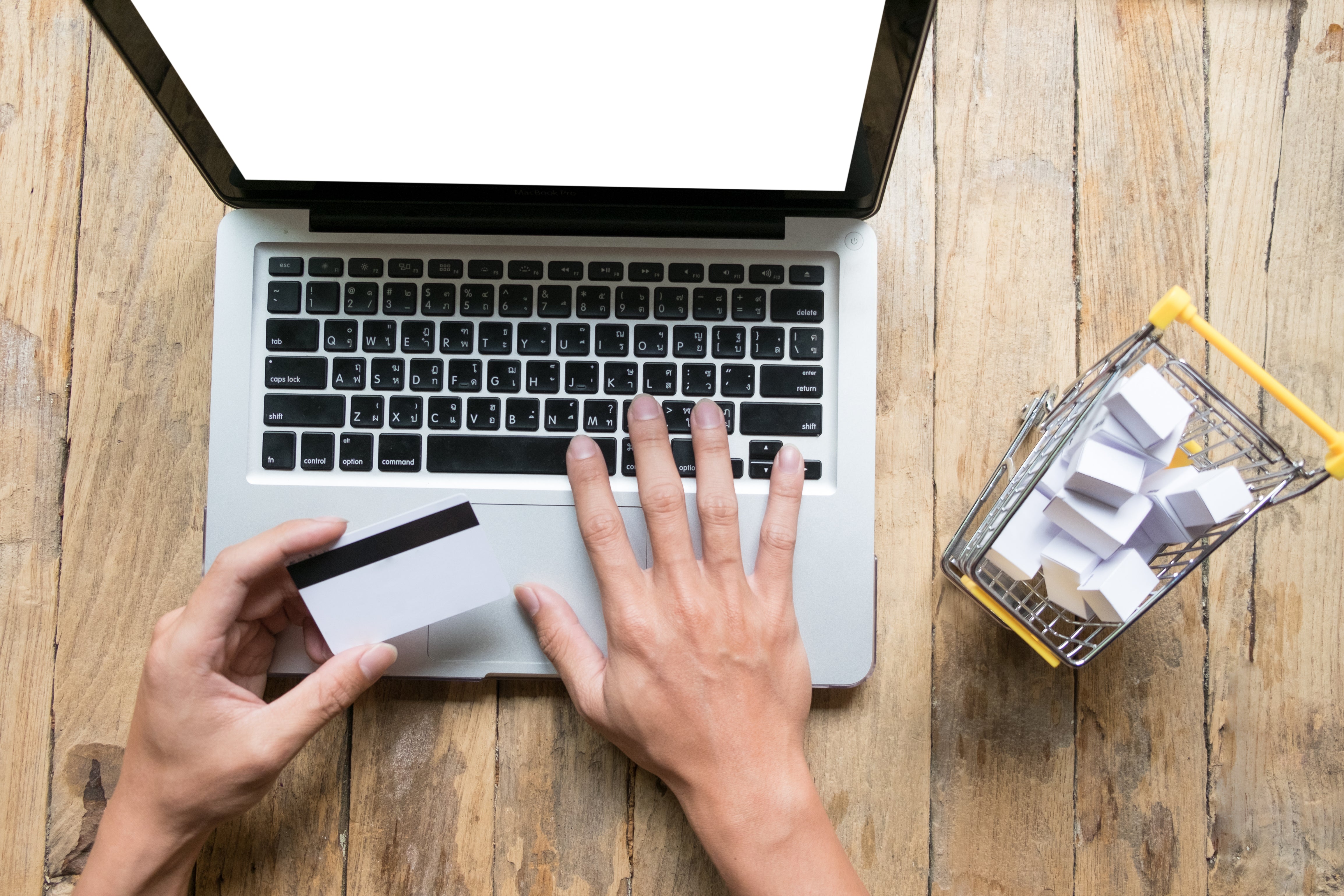 man-holding-credit-card-hand-entering-security-code-using-laptop-keyboard.jpg